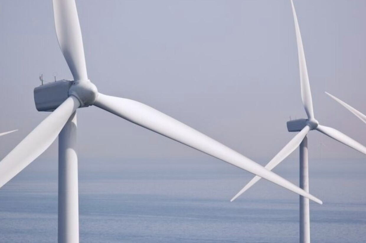 Wind turbines standing in ocean waters.