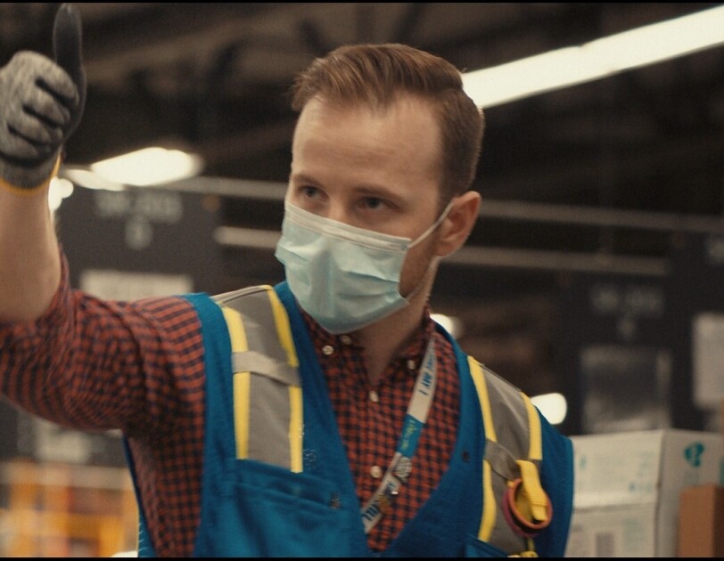 Amazon employee with thumb up and wearing mask