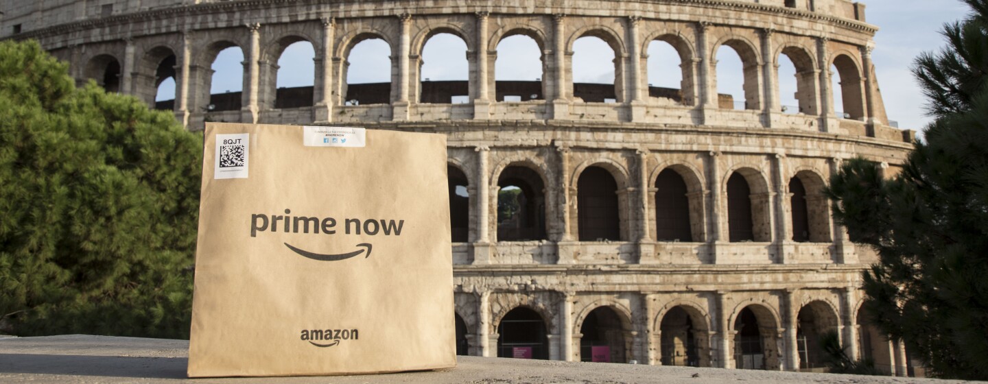 Package with Amazon and Prime Now logo on the front sits across the Colosseum in Rome.