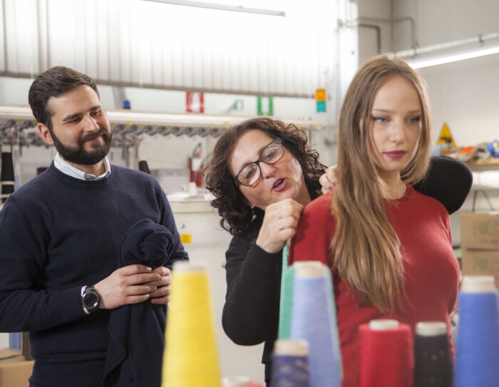 L'imprenditore leonardo Dondini nel maglificio di famiglia insieme ad un'impiegata, provando un capo di cashmere su una modella