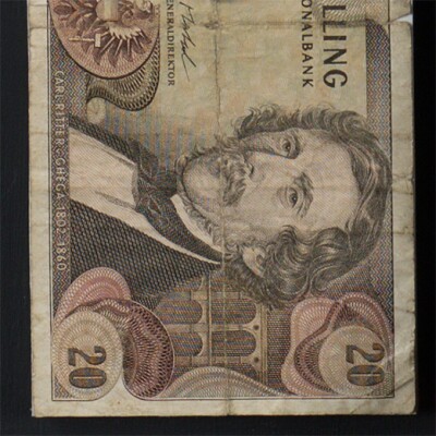 Detail of a piece of old Austrian paper currency. The image includes the number 20 at the corners of the bank note as well as a well as a portrait of a man with a mustache. A label beneath the portrait says "Carl Ritter v. Ghegha 1802 - 1860."