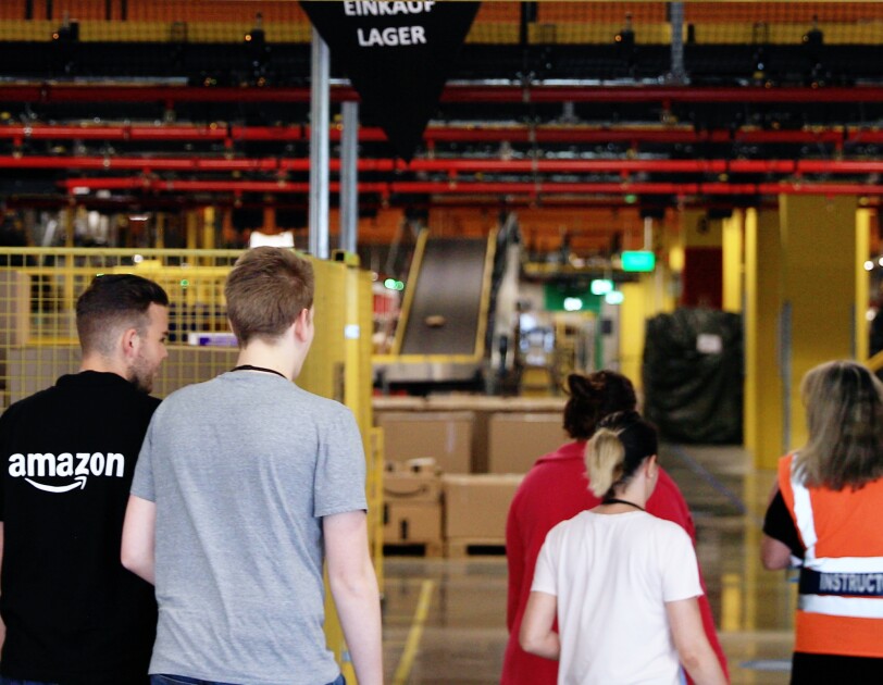 Das Team von Amazon Frankenthal im Logistikzentrum unter dem Banner: work hard. have fun. make history.