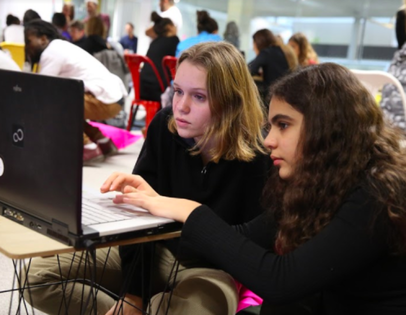 Deux jeunes filles travaillent en groupe sur un ordinateur.