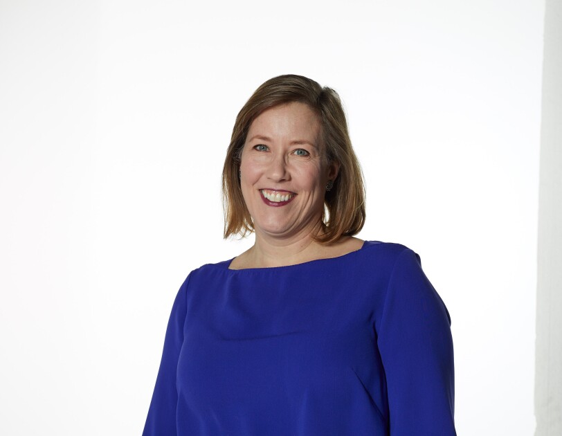 Female wearing a blue jumper smiling directly at the camera