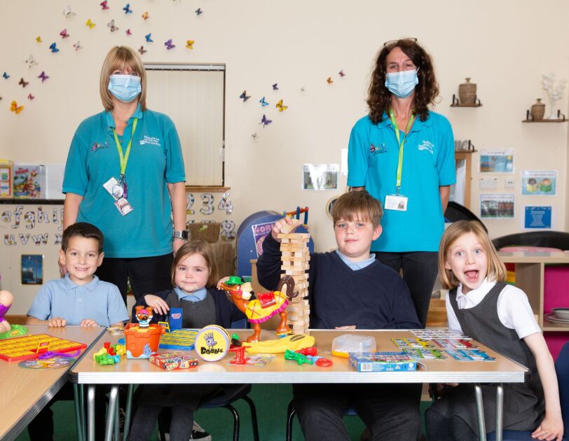 Barnardos Partnership, volunteers with students, in front of them is a table full of games.