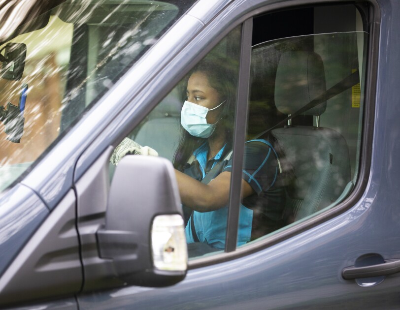 A woman driving an Amazon delivery vehicle
