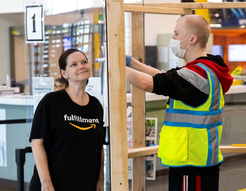 Amazon associate in a fulfillment center following additional safety proceedures in response to the COVID-19 pandemic