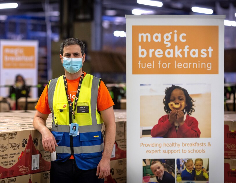 Amazon employee stood next to a Magic breakfast sign and cereal boxes