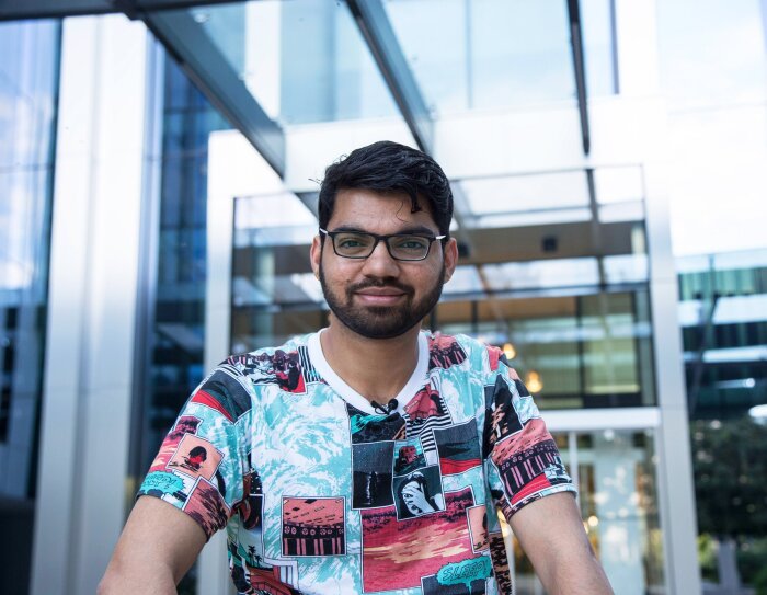 Siddhesh Krishnan, Learning & Development Associate ad Amazon, sorride in posa davanti all'ingresso degli uffici Corporate Amazon di Milano.