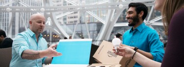 Three Amazon employees discuss Frustration-Free Packaging during a meeting in the Amazon's Seattle Spheres.