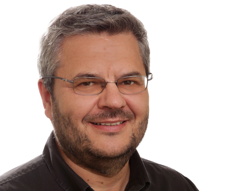 Daniel Marcu, director of machine translation and natural-language processing at Amazon. He is wearing a brown shirt and has glasses and a beard.