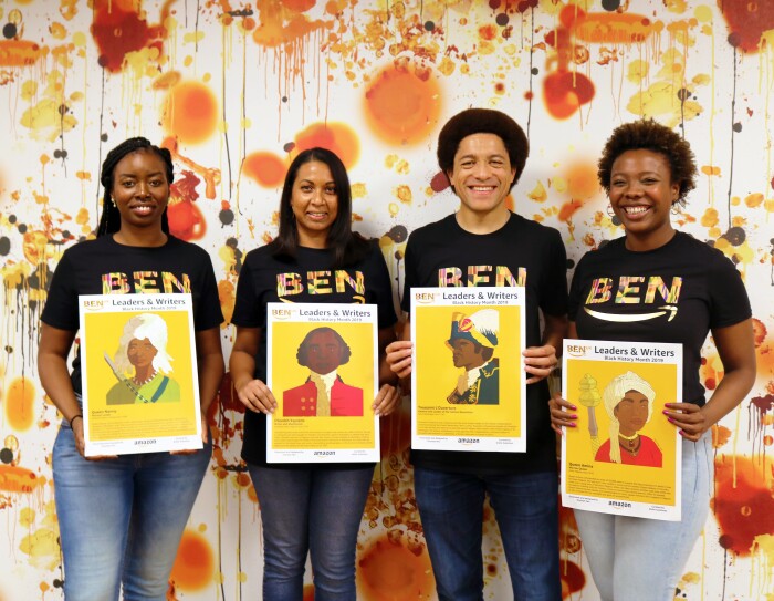 Orange and white group shot of employees holding artwork for BEN