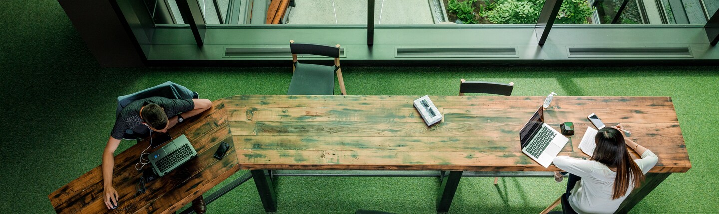 Two Amazon employees work on opposite ends of a long decorative table