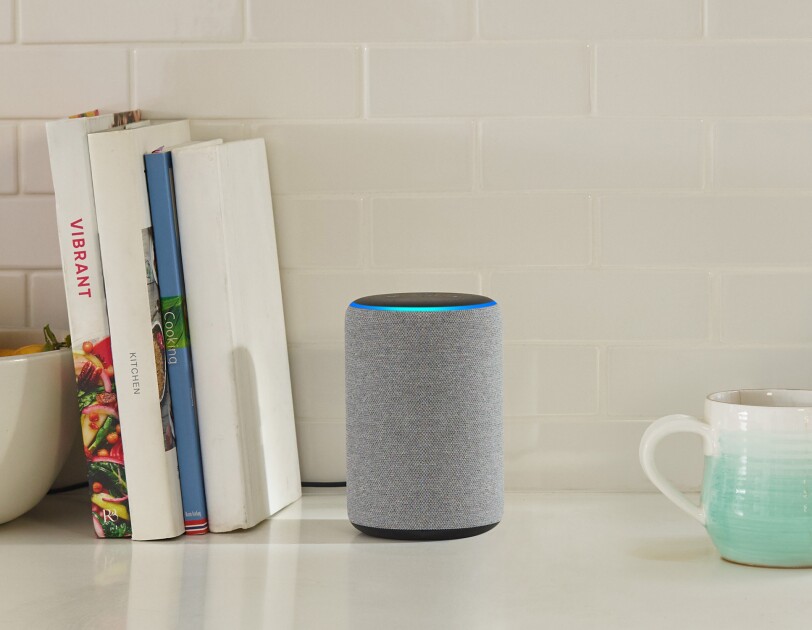 Echo device in a kitchen. To the left are cookbooks, to the right is a stoneware mug that fades from aqua to white.