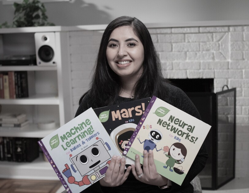 A woman holds three books for children that she self-published on KDP