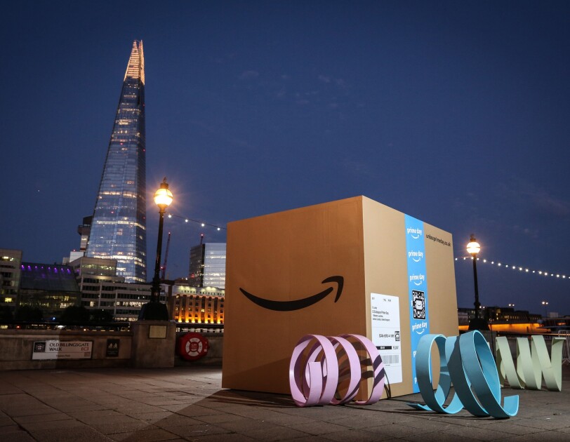 A giant Amazon box (about 8ft by 8ft) at dusk in London with the Shard in the background
