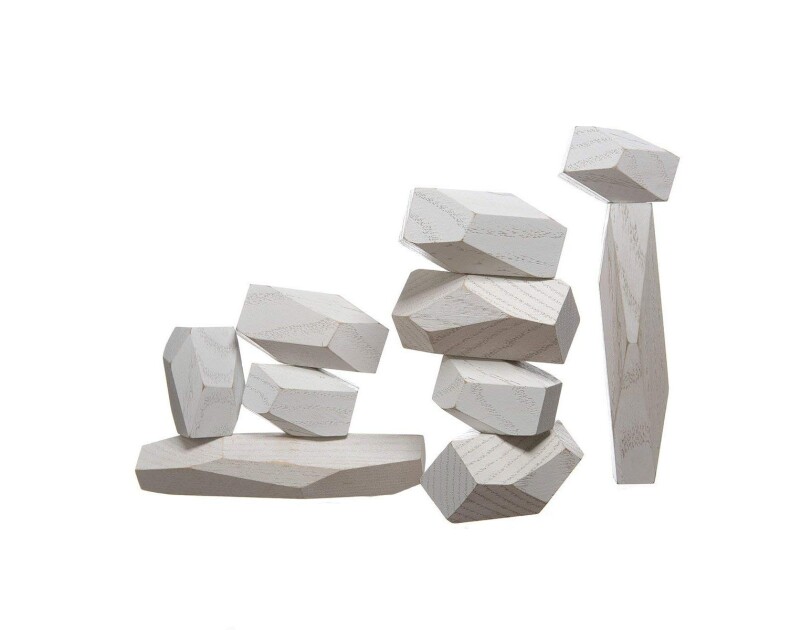 A stack of four balancing blocks next to a taller stack of a vertical block, topped with 5 additional wood blocks, all of varying shapes and sizes.