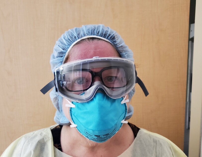 A woman wearing PPE has her Echo Frames on under her goggles, as a Physician's Assistant.