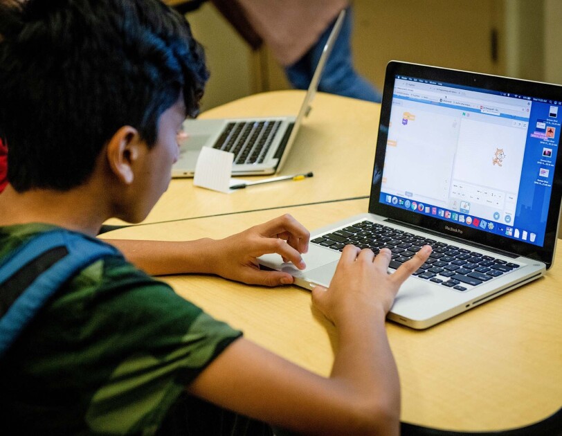 Students work on coding programs on laptop computers in a classroom at a New York City school.