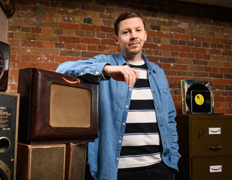 Rapper and mental health advocate, Professor Green, standing next to some vintage speakers.