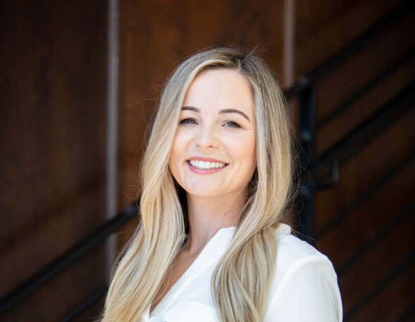 A headshot of Courtney Jones, CEO and founder of the ClearTheList Foundation and #ClearTheList, smiling against a black background.