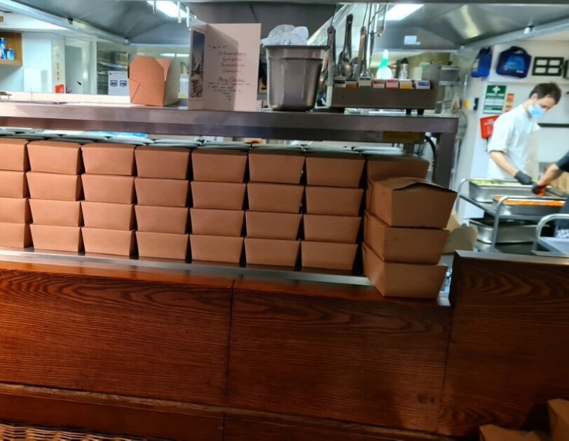 Food boxes at Waterhouse Restaurant on a counter ready for delivery.