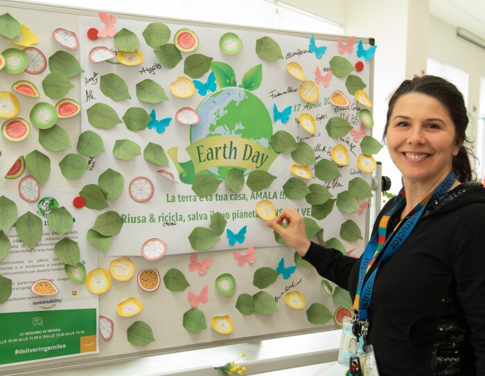 Dipendente del centro di distribuzione Amazon di Passo Corese attacca un post-it su una lavagna in occasione dell'Earth Day