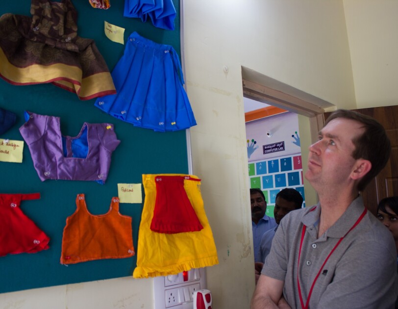 John Felton looks at some clothes stitched by women at the Community Centres.