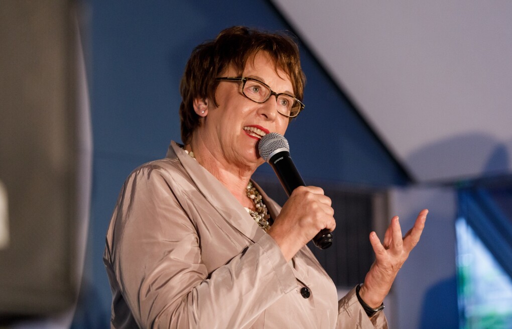 Brigitte Zypries steht auf der Bühne, sie hält ein Mikrofon in der Hand und schaut freundlich ins Publikum