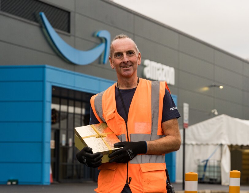 Phil Hayden holding a present outside his Amazon site