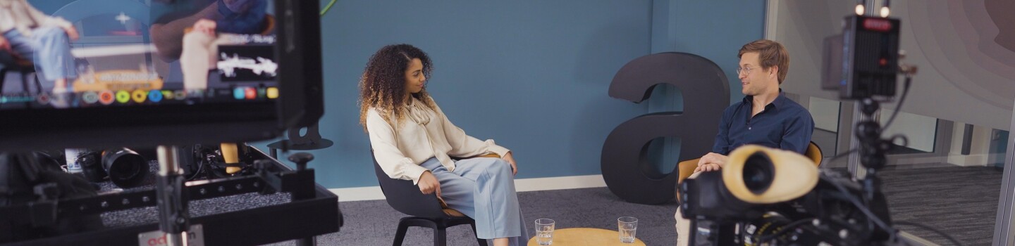 Cherifa und Ole sitzen im Amazon Büro und unterhalten sich.