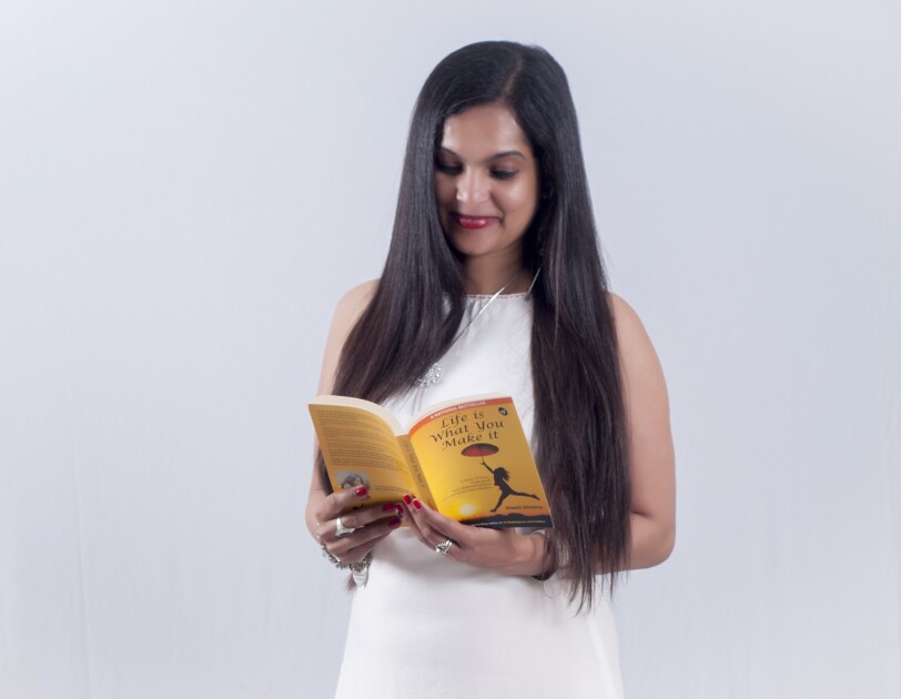 Author Preeti holds a book authored by her and is reading it