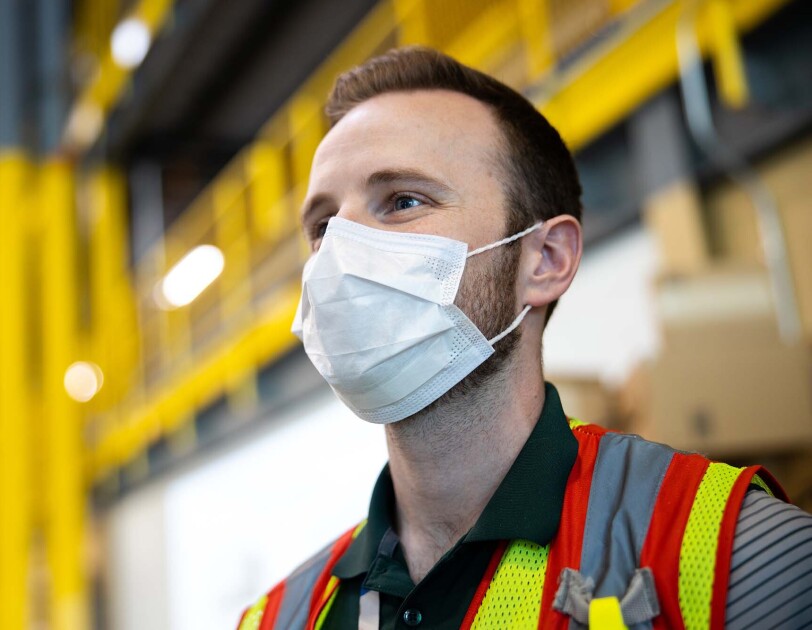 Amazon associate in a fulfillment center following additional safety proceedures in response to the COVID-19 pandemic