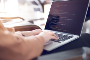 Close up Woman hands coding html and programming on screen laptop.