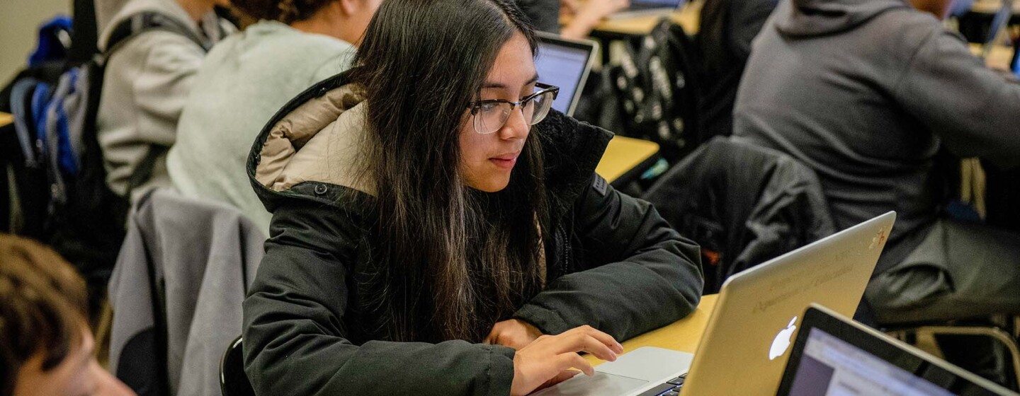 Students work on coding programs on laptop computers in a classroom at a New York City school.