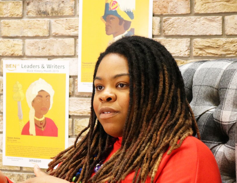 Artist Onyinye Iwu discussing Black History Month in front of her artwork