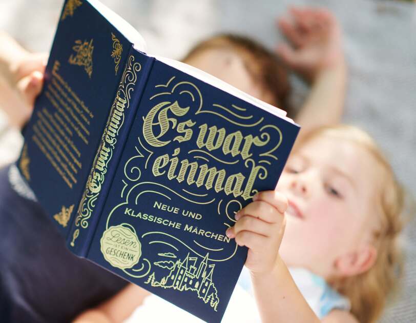 Zwei Kinder lesen zusammen in einem Märchenbuch