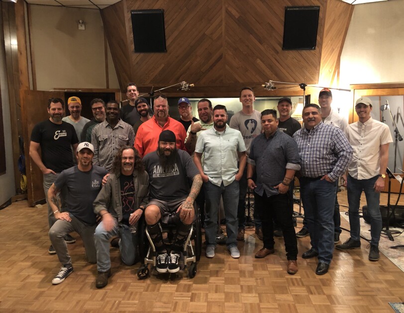 A group of men gather inside a recording studio (image taken before COVID-19 pandemic)