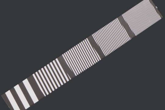 Alternating black and white lines are spaced widely apart on the bottom left of the image and packed close together on the top right.