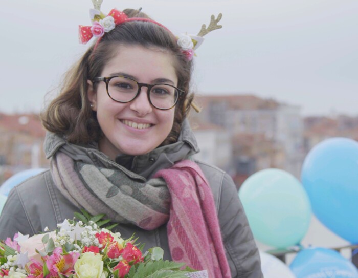 Carlotta sorridente a Venezia, con un mazzo di fiori e palloncini