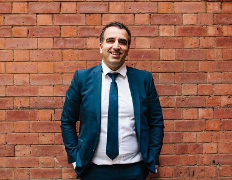 Ali Nowroozi, Founder of Masumi, standing in front of a brick wall.