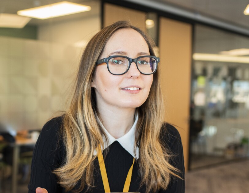 Female employee wearing glasses and sat in an Amazon office