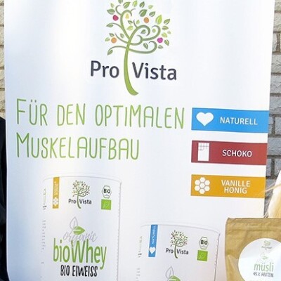 Die Gründer von Pro Vista präsentieren ihrer Marke und Produkte. Im Hintergrund ist ein Werbe-Banner von Pro Vista zu sehen.