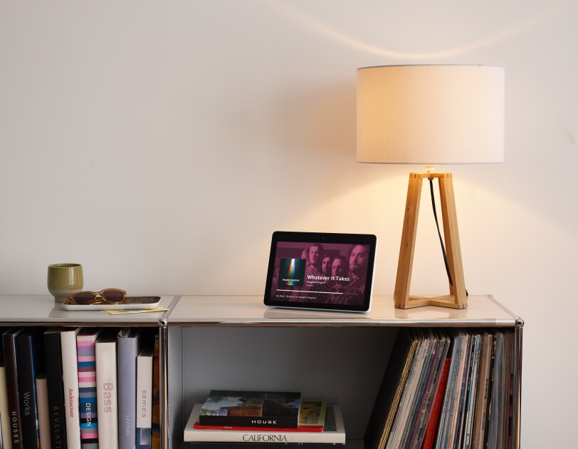 Echo Show on small bookshelf showing music streaming