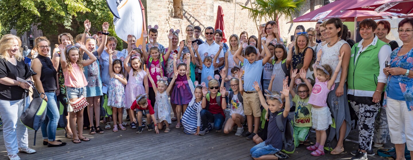 Das Gruppenbild zeigt rund 150 Personen, darunter Kinder und Erwachsende, vor der Stiftsruine, in der das Theaterstück aufgeführt wurde.