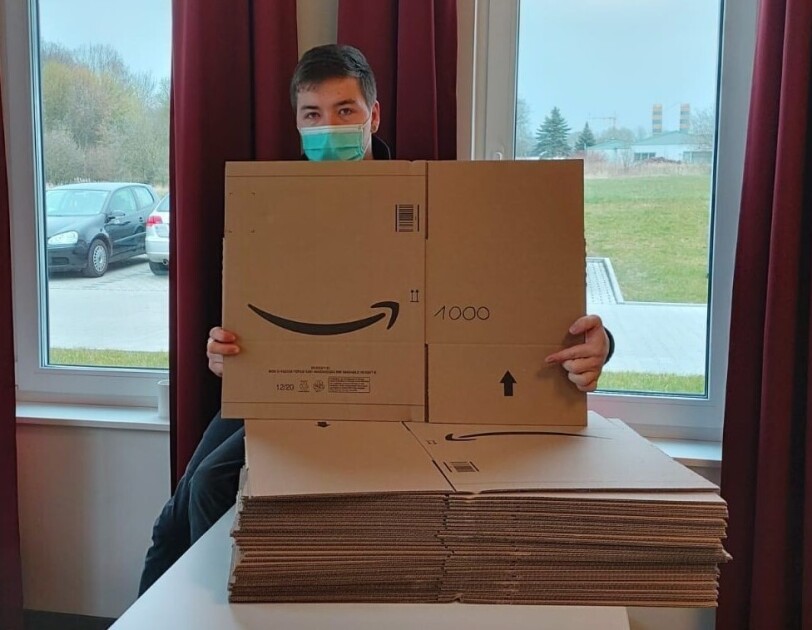 Kartons werden von einem der DRK Mitarbeiter gezeigt.