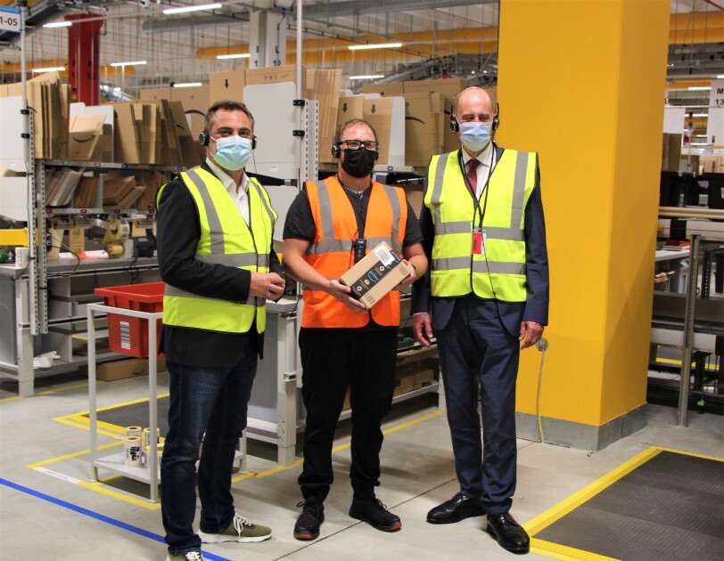 Minister und OB mit einem Amazon Mitarbeiter auf der Lagerfläche.