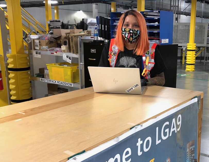 Woman Amazon associate wearing a mask while working