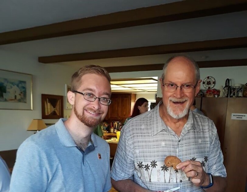 Two men stand together in a living room. Tim (left) received a kidney from his uncle Jerry (right) and pose together for an image.