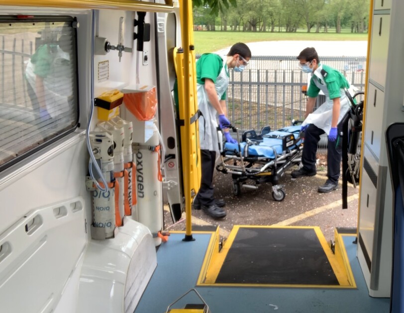 Back of an ambulance with paramedics at work in shot